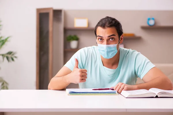 Ung manlig student som studerar hemma under en pandemi — Stockfoto