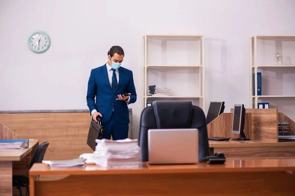 Young male employee working in the office wearing mask — Stock Photo, Image