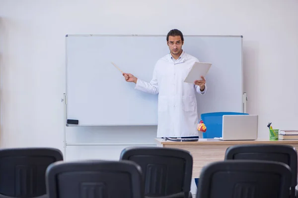 Jonge mannelijke arts geeft seminar in de klas — Stockfoto