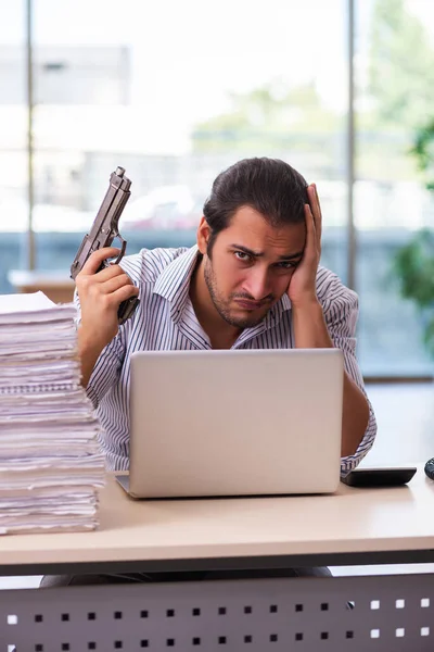 Young male employee unhappy with excessive work in the office