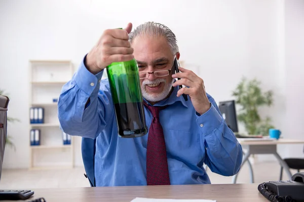 Un vieil employé boit de l'alcool au bureau — Photo