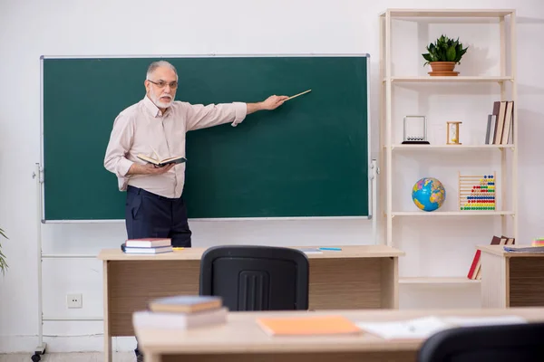 Oude mannelijke leraar voor schoolbord — Stockfoto