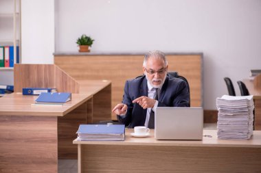 Ofiste çalışan yaşlı bir erkek.