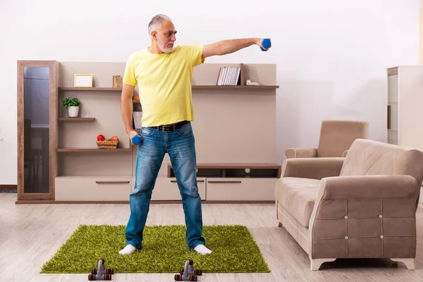 Yaşlı adam evde spor egzersizleri yapıyor. — Stok fotoğraf