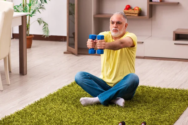 Yaşlı adam evde spor egzersizleri yapıyor. — Stok fotoğraf