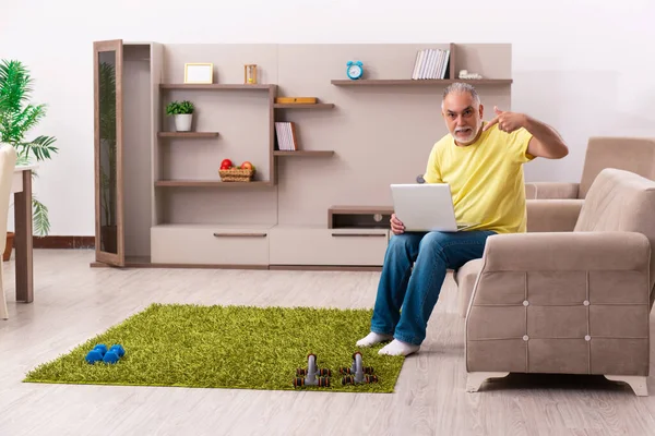 Homem idoso fazendo exercícios esportivos em casa — Fotografia de Stock