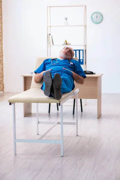 Velho médico masculino extremamente cansado após o turno da noite — Fotografia de Stock