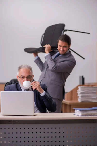 Gammal chef och ung manlig assistent på kontoret — Stockfoto