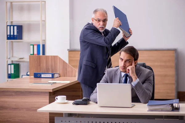 Vecchio capo e giovane assistente maschile in ufficio — Foto Stock