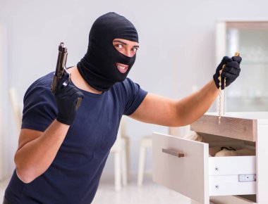 Soyguncu kar maskesi takıp değerli şeyler çalıyor.