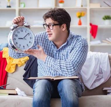 Genç adam dağınık bir odada çalışıyor.