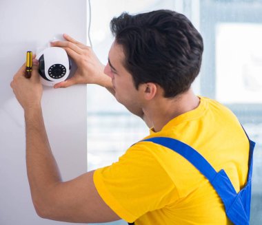 Müteahhit ofise güvenlik kamerası yerleştiriyor.