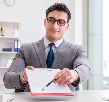 İşadamı ofiste iş belgelerini imzalıyor