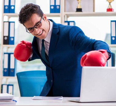 Ofiste kızgın boks eldivenli bir iş adamı.