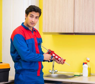 Mutfakta çalışan bir tamirci.