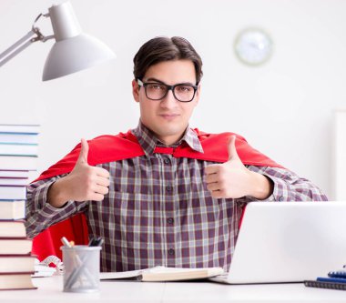 Dizüstü bilgisayarı olan süper kahraman öğrenci sınavlara hazırlanıyor.