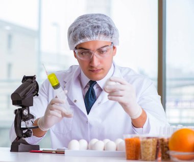 Besin uzmanı gıda ürünlerini laboratuarda test ediyor.