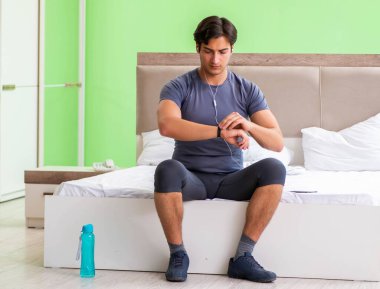 Genç yakışıklı adam otel odasında sabah egzersizi yapıyor.