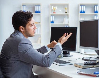 Birçok ekranın önünde oturan bir iş adamı