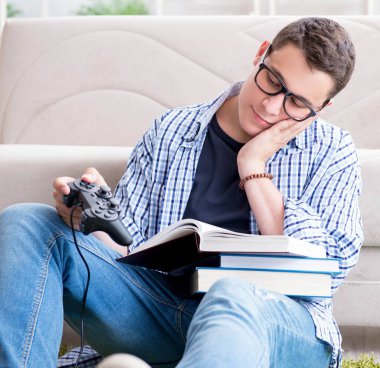 Çalışmayı ve oyun oynamayı dengelemeye çalışan genç öğrenci