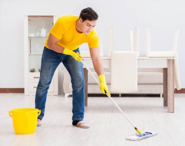 Evdeki işleri yapan genç adam.