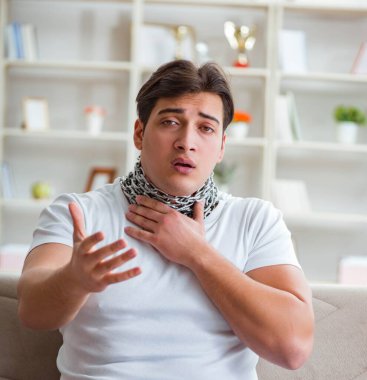 Genç adam boğaz ağrısı çekiyor.