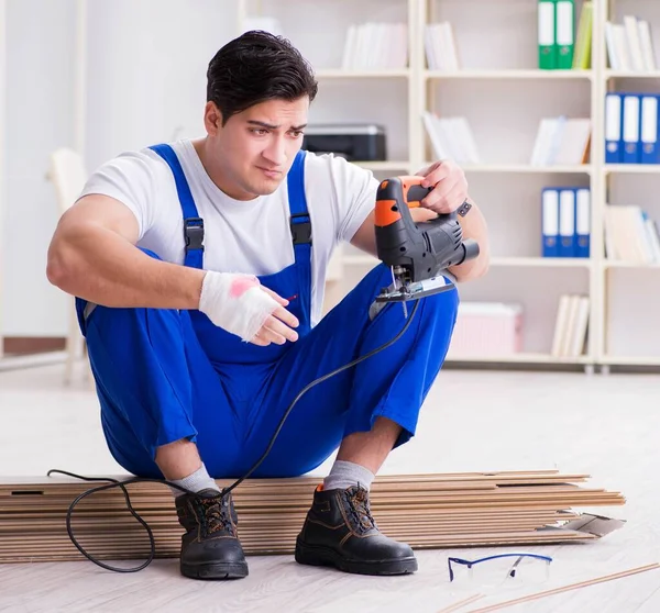 Trabajador joven que trabaja en baldosas laminadas piso — Foto de Stock