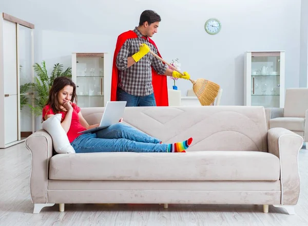 Marido super-herói ajudando sua esposa em casa — Fotografia de Stock