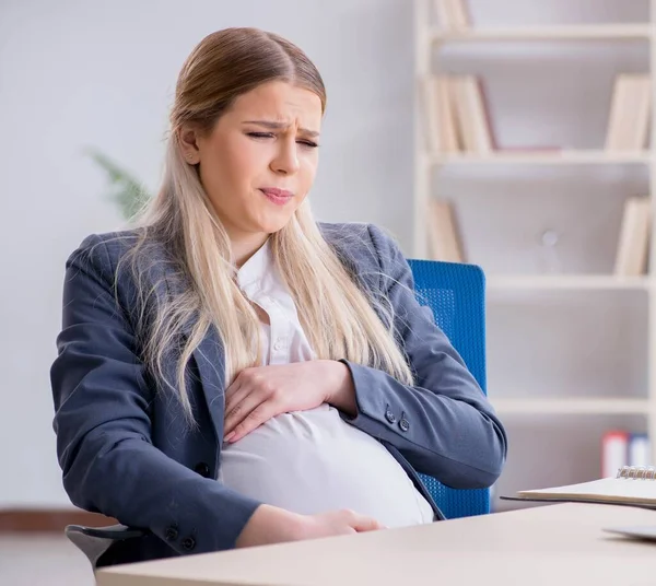 Pracownica w ciąży w biurze — Zdjęcie stockowe