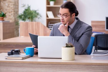 Ofiste çalışan genç bir erkek.