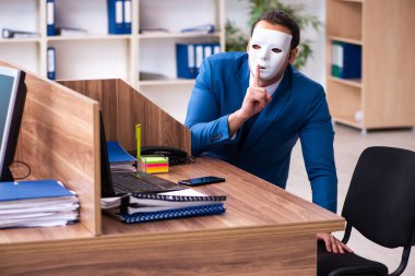 Ofiste maske takan genç bir erkek.