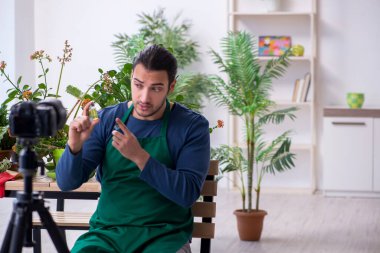 Evin içinde bitkileri olan genç bir erkek bahçıvan.