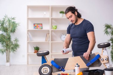 Kaykay tamir eden genç bir erkek tamirci.