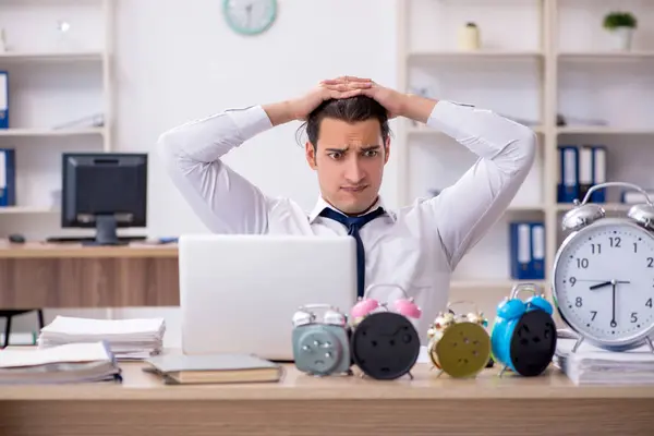 Jovem empregado do sexo masculino com medo de perder prazo no local de trabalho — Fotografia de Stock