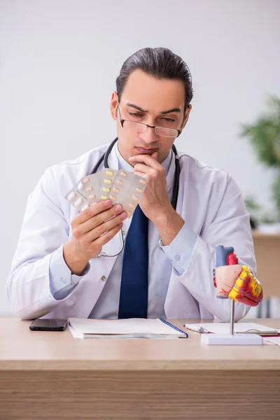 Young male doctor cardiologist suggesting pills — Stock Photo, Image