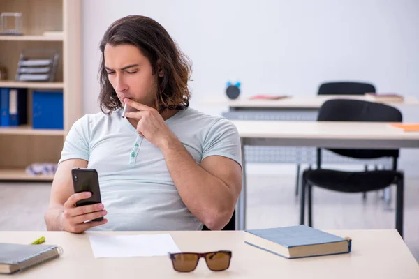 Mladý muž student kouření cigarety ve třídě — Stock fotografie