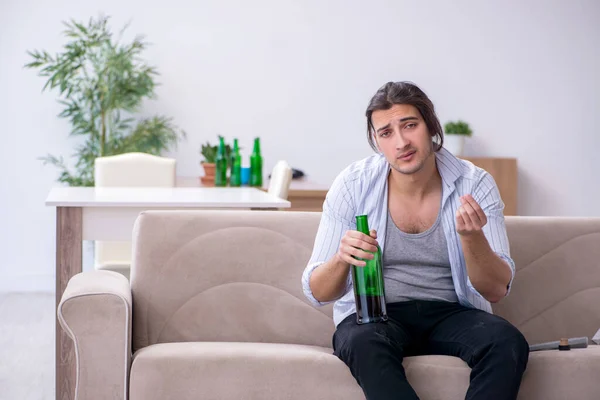 Mladý alkoholik pije víno doma — Stock fotografie