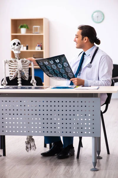 Ung manlig läkare radiolog och skelett patient på kliniken — Stockfoto