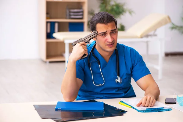 Young male doctor committing suicide at workplace — Stock Photo, Image