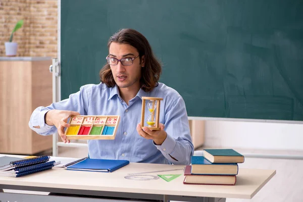 Mladý muž učitel před zelenou tabuli — Stock fotografie
