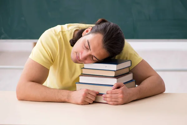 Giovane studente maschio che si prepara per gli esami in classe — Foto Stock