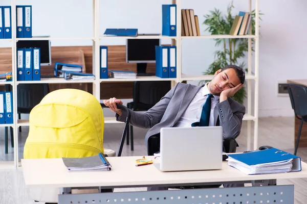 Joven empleado masculino que cuida del recién nacido en el lugar de trabajo — Foto de Stock