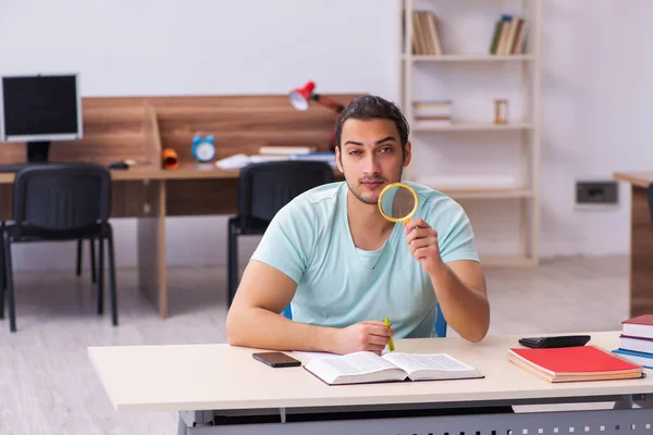 Ung manlig student förbereder sig för tentor hemma håller loupe — Stockfoto