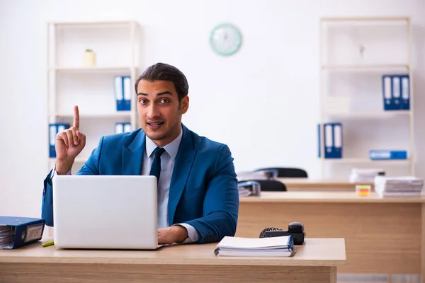 Young male employee and too many work in the office — Stock Photo, Image