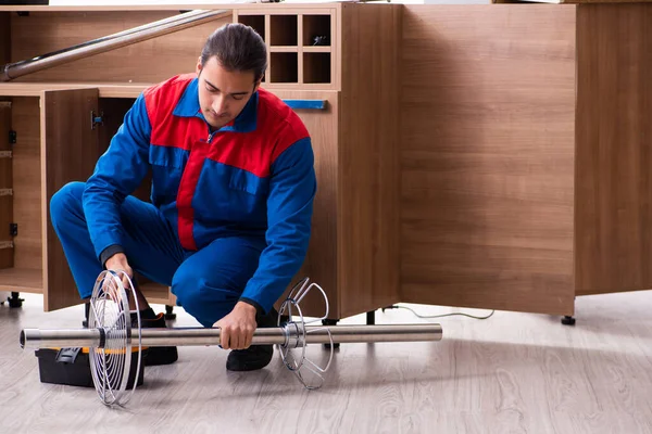 Genç yakışıklı erkek marangoz içeride çalışıyor.