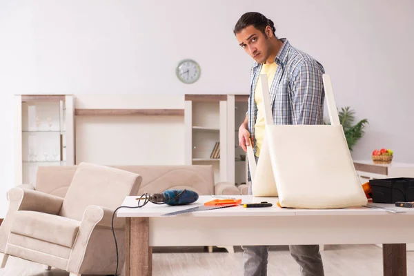 Jovem carpinteiro masculino reparando móveis em casa — Fotografia de Stock