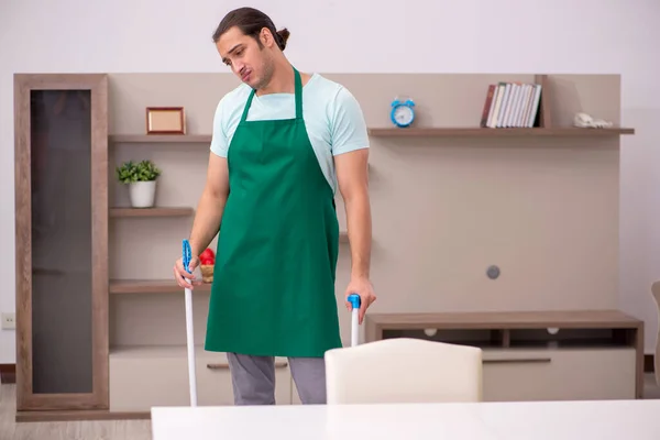 Jovem empreiteiro limpando a casa — Fotografia de Stock