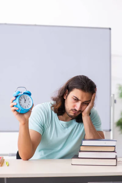 Joven estudiante masculino preparándose para los exámenes en la gestión del tiempo concep — Foto de Stock