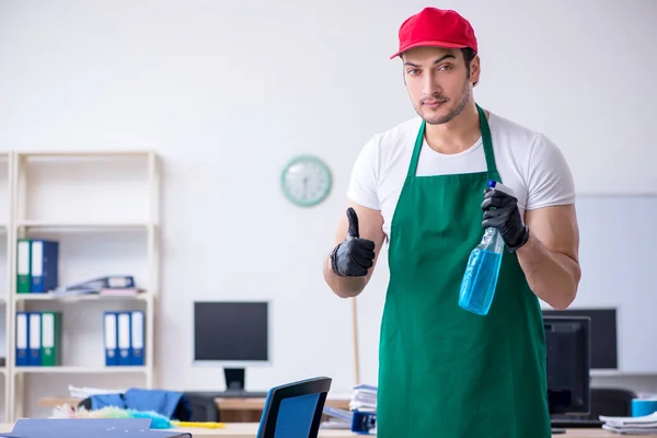 Jovem empreiteiro limpando o escritório — Fotografia de Stock