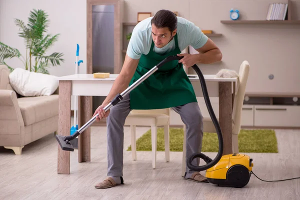 Joven contratista masculino limpiando la casa —  Fotos de Stock